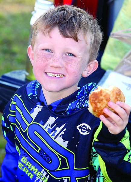 Grayson Holland enjoys a biscuit from Campfield Memorial Baptist Church at Ellenboro\'s yard sale.