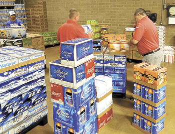 Assistant Warehouse Manager Randy Norton, Richard Martin and Shannon Murray work to build an order for distribution. Fox Distributing is on target to deliver 1.1 million cases in 2015. 