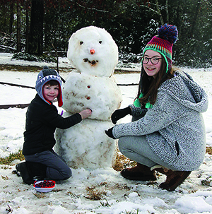 Brother and Sister Walter and Elizabeth Wilson make a snowman after 2 inches of Snow fell in the area on February 7th 2021. 
