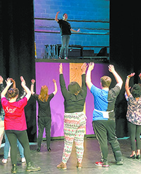 A rehearsal of a scene where The Wiz, top, played by Tori  Lawrence, gets ready to leave Oz in the balloon.  